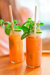 Two Refreshing Iced Beverages With Mint and Lime on Wooden Table