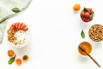 Flat lay of oatmeal granola and ingredients served on white table. Healthy breakfast