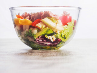 Fresh salad with tuna, peppers, tomato in glass bowl on a simple table cloth. Home made food made from fine high quality ingredients. Weight loss meal.