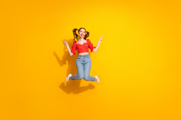 Obraz premium Photo of young girl wearing new clothing summer season style stick tongue and jumping v sign isolated on yellow color background
