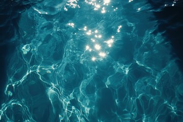 Sunlit water surface with ripples sparkling reflections in a clear pool sea or blue ocean viewed from above