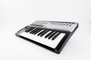Modern Black and White MIDI Keyboard With Control Pads in a Studio Setup