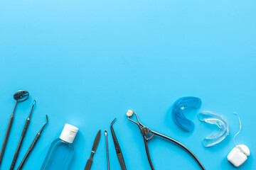Dental instruments and oral care products on a blue background. Concept of tooth treatment and...