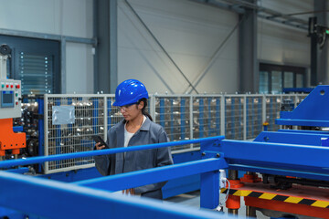 Female engineer check control heavy machinery in Industrial factory for maintenance and safety.