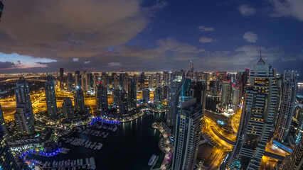 Dubai Marina skyscrapers and jumeirah lake towers view from the top aerial night to day timelapse in the United Arab Emirates.