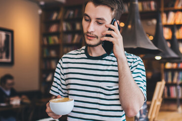 Thoughtful male answering phone call in library