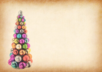 colorful Christmas balls stacked wreath in christmas tree shape on antique cracked paper texture