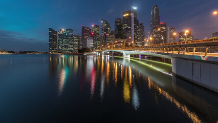 Obraz premium Esplanade bridge and downtown core skyscrapers in the background Singapore night to day timelapse
