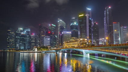 Fototapeta premium Esplanade bridge and downtown core skyscrapers in the background Singapore night timelapse hyperlapse