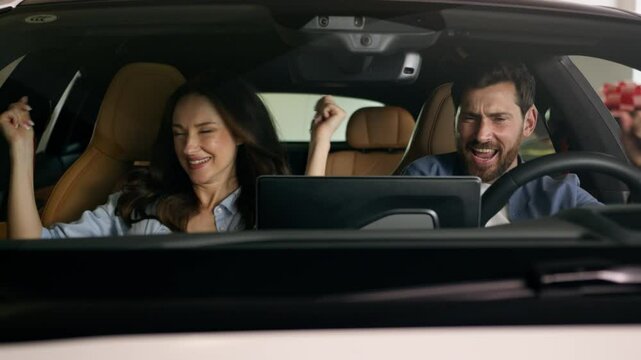 Happy dancing funny moving to music radio technology audio stereo system inside car Caucasian couple in auto dance woman girl female girlfriend with man guy male boyfriend travel joy automobile auto