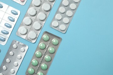 Various blisters with tablets on a colored background
