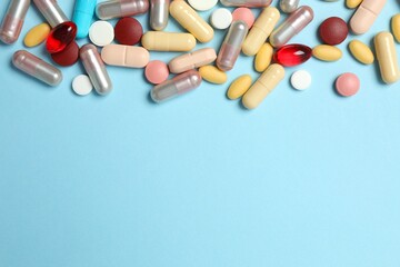 Various tablets and capsules on a colored background