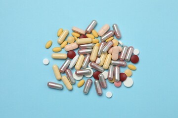 Various tablets and capsules on a colored background
