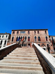 Fototapeta premium Historic brick building with stairs under clear blue sky. Venice, Italy.