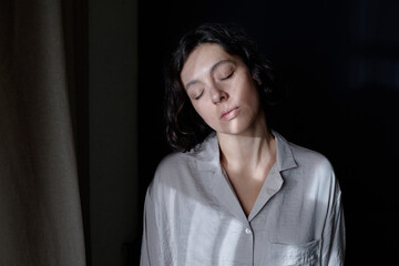 High angle shot of sleepy woman in grey pajamas suffering from somnambulism