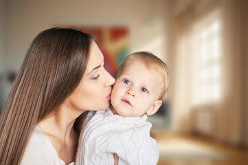 Loving mother carrying newborn baby at home.