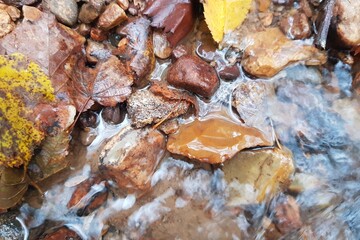 Flint scraper sticking out of water in a stream, Stone Age artifact at the place of discovery, in situ. Central Russia