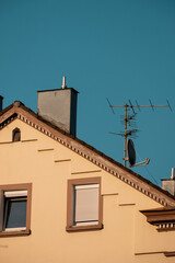 Hauswand mit Fenstern vor blauem Himmel