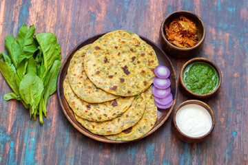 Palak paratha is a soft, spinach-filled flatbread, served with creamy, spiced palak paneer—a flavourful spinach and cottage cheese curry.