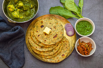 Palak paratha is a soft, spinach-filled flatbread, served with creamy, spiced palak paneer—a flavourful spinach and cottage cheese curry.