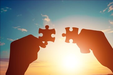 Man and woman hands holds jigsaw puzzle.