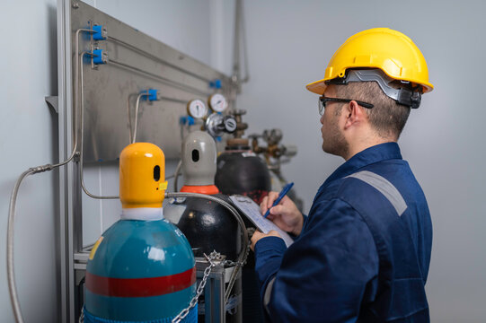 Asian engineer working at Operating hall,Thailand people wear helmet  work,He worked with diligence and patience, checked the valve regulator at the hydrogen tank.