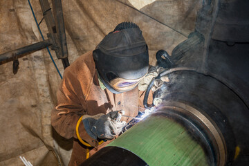 Schwei&szlig;er bei der Arbeit an Rohrverbindung auf Baustelle