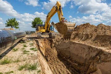 Bagger gr&auml;bt Graben f&uuml;r Rohrverlegung auf Baustelle