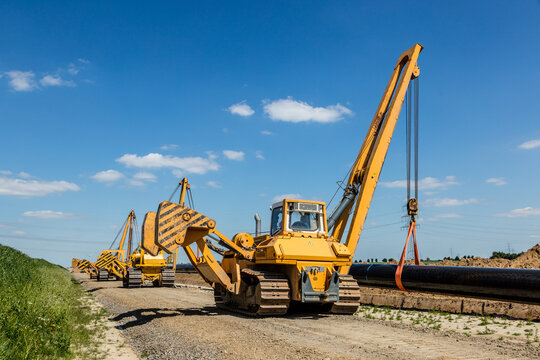 Gelbe Kettenkr&auml;ne bei Rohrverlegung auf Baustelle