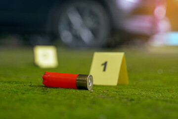 Bullet casings fell on the moss growing on the cement floor and blurry background of the evidence...