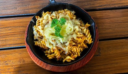 Fusilli pasta with mozzarella cheese on hot plate