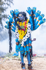 Kulasai Dasara, Portrait of indian male with painted face and dressed as hindu goddess kali to...