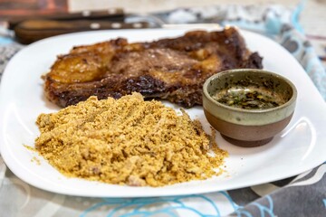Typical Brazilian lunch with grilled steak, farofa and sauce