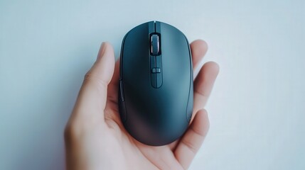 Ergonomic black wireless mouse in hand against minimalist background