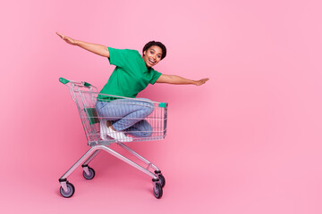 Full size photo of pretty young girl ride shopping cart spread hands have fun wear trendy green...