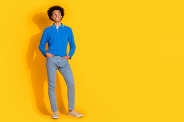 Fototapeta premium Full length photo of handsome young guy look empty space dressed stylish blue garment isolated on yellow color background