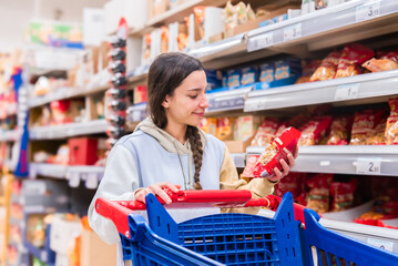 Woman shopping in a supermarket aisle