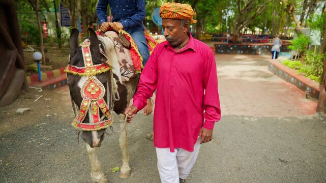 Man Walk in Traditional Attire with Decorated Horse