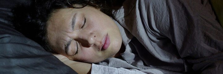 Website banner with woman worrying and having nightmare while sleeping in bed at night