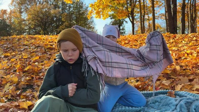 Brother and sister have a good time in the autumn park.