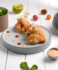 Crispy fried chicken with sauce and salad side and Mushroom soup bowl, white wood background