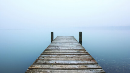 Fototapeta premium Serene Misty Dock Over Calm Waters at Dawn, Inviting Reflection and Tranquility in a Minimalistic Natural Landscape