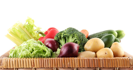 Different ripe vegetables in wicker box isolated on white