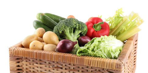 Different ripe vegetables in wicker box isolated on white