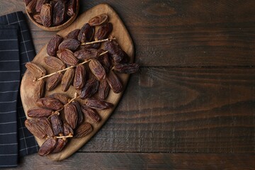 Tasty dried dates on wooden table, top view. Space for text