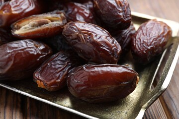 Many tasty dried dates on wooden table, closeup