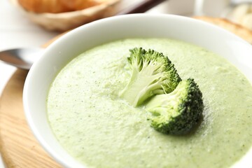 Delicious broccoli cream soup served on table, closeup
