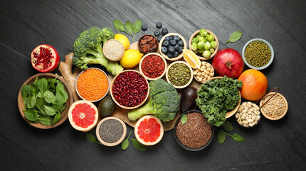 Different superfood products on black table, flat lay