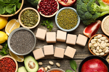Different superfood products and blank cubes on wooden table, flat lay. Space for text