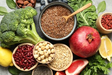 Different superfood products on grey table, top view